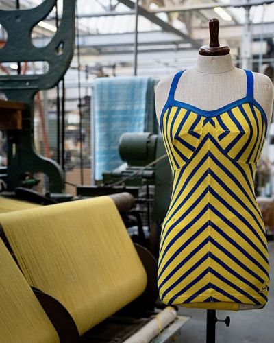 tricot badpak in geel en blauw op een paspop in de weverij in Geldrop