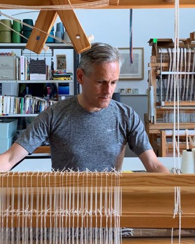 Theo Rooden werkt aan een weefgetouw