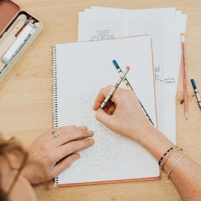 tekenende handen bij een notitieboek