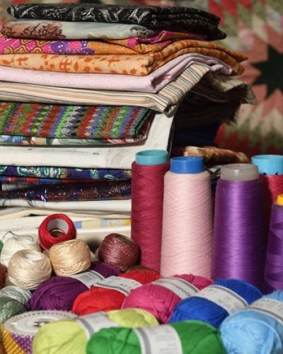 kleurige verzameling garens, lapjes en boeken die te koop zullen zijn op het handwerkfestijn op 13 en 14 juni 2025